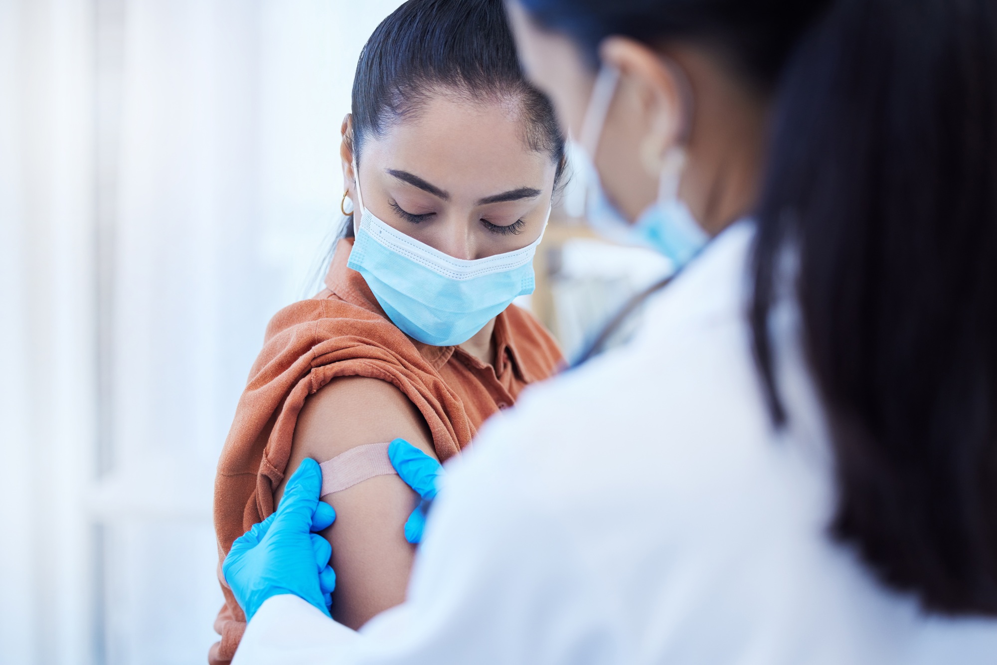 Covid vaccine, doctor and patient with face mask for safety, compliance and healthcare at a hospita