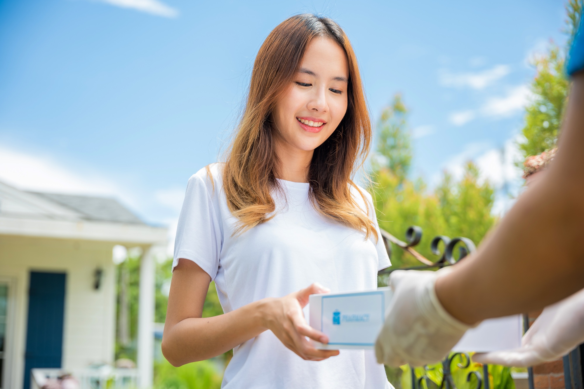 Sick Asian young woman receive medicine first aid pharmacy box from hospital delivery service